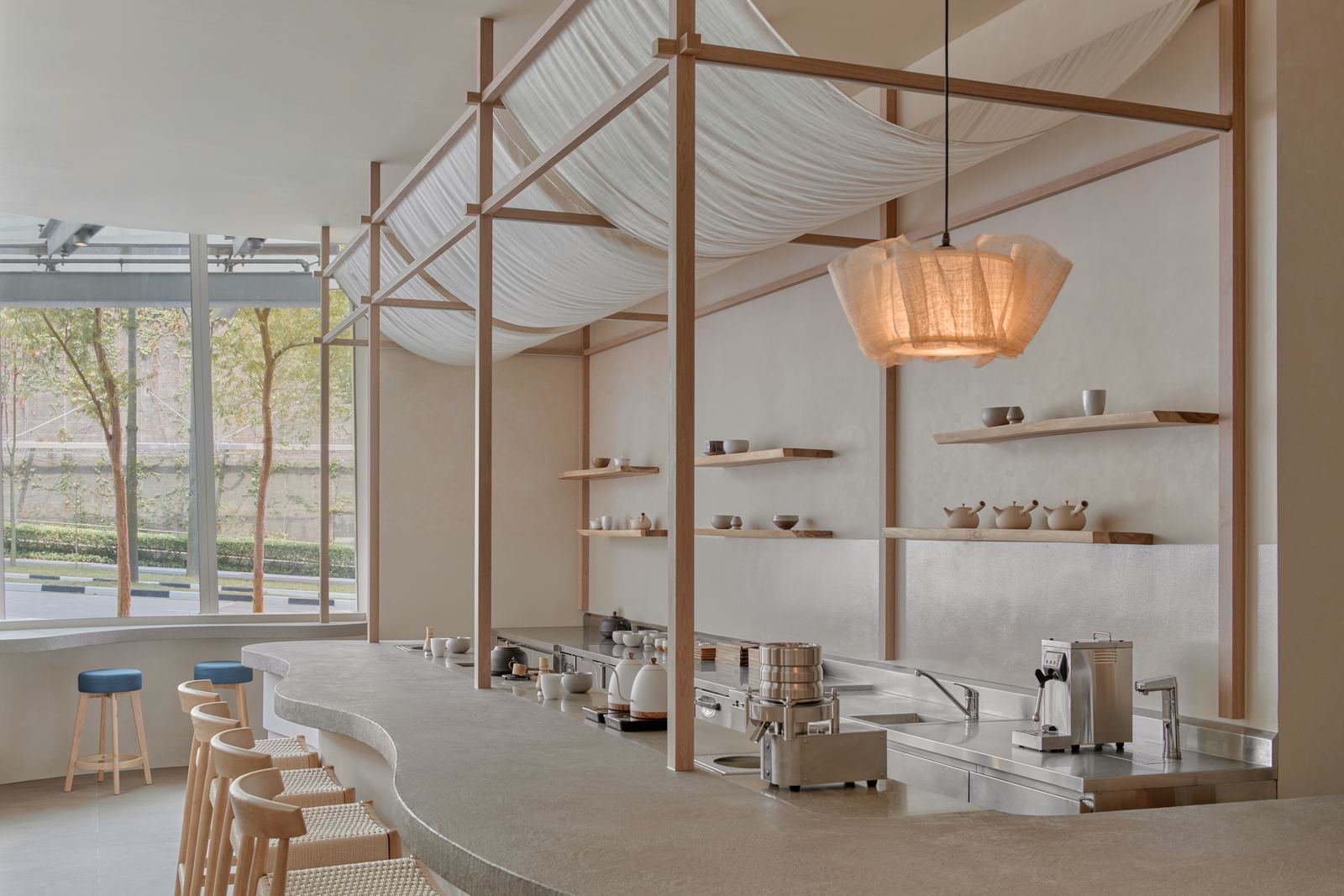 The KOKO Kawane counter: teaware on timber shelves under a draped muslin canopy